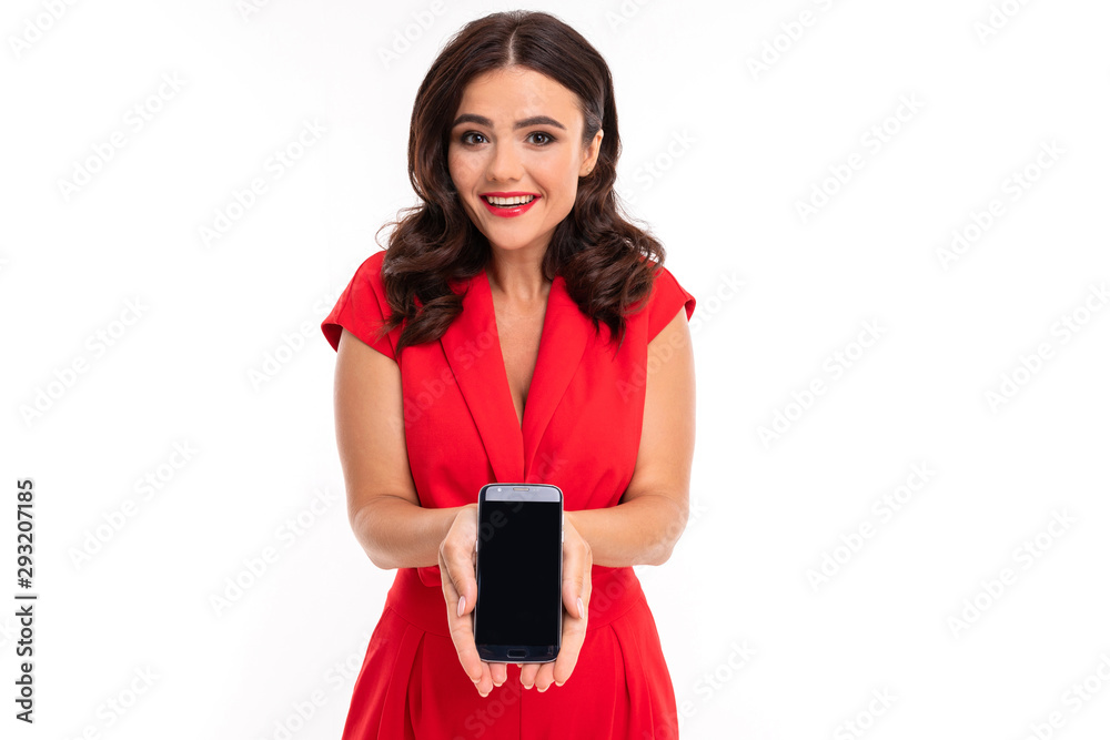 Naklejka premium charming brunette holds a phone in her hand carefully