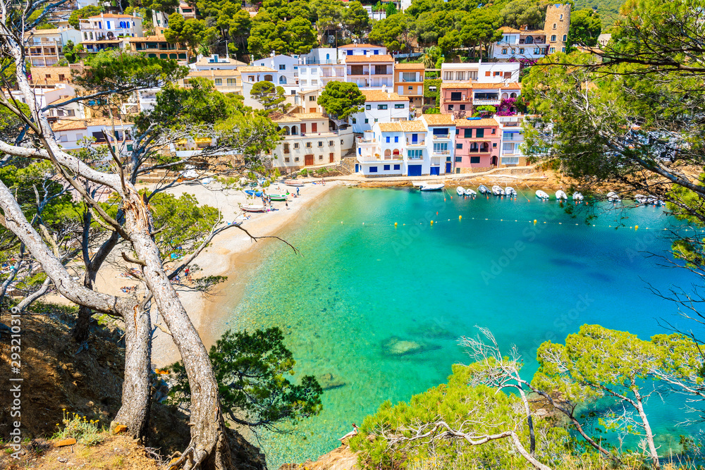 View of beach in Sa Tuna fishing village with colorful houses on shore, Costa Brava, Catalonia, Spain