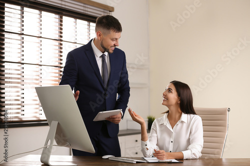 Man helping his colleague with work in office