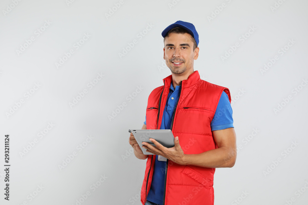 Happy young courier with tablet on white background Happy young courier with tablet on white background