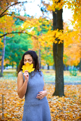 woman posing with autumn leaves in city park, outdoor portrait