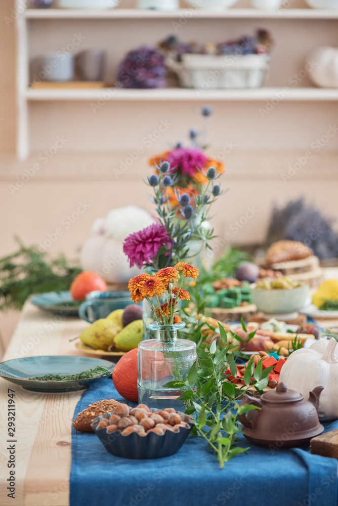 Festive autumn table with flowers, white pumpkin and tea