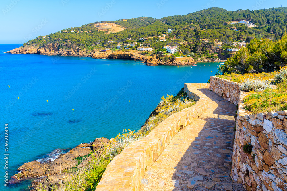 Path from Sa Riera village to Cala Moreta beach and view of blue sea and rocks, Costa Brava, Catalonia, Spain