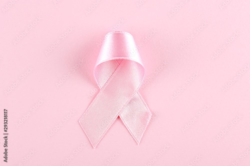 The pink colored ribbon - international symbol of breast cancer awareness and moral support for women. Isolated background, copy space, close up, top view fat lay.