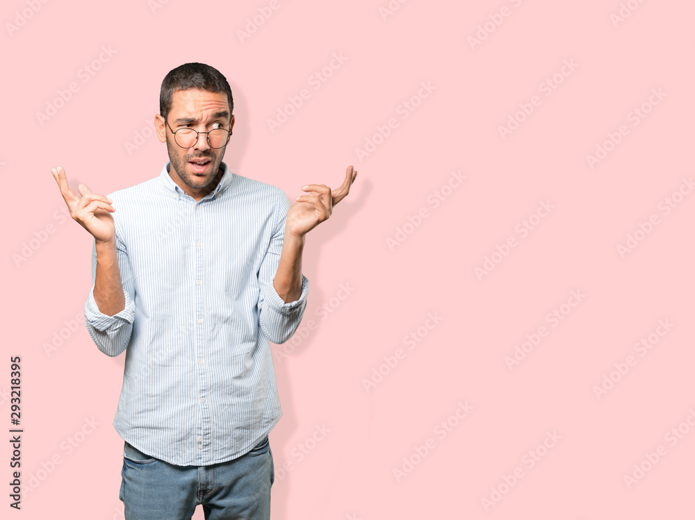 Concerned young man doing a gesture of confusion Concerned young man doing a gesture of confusion