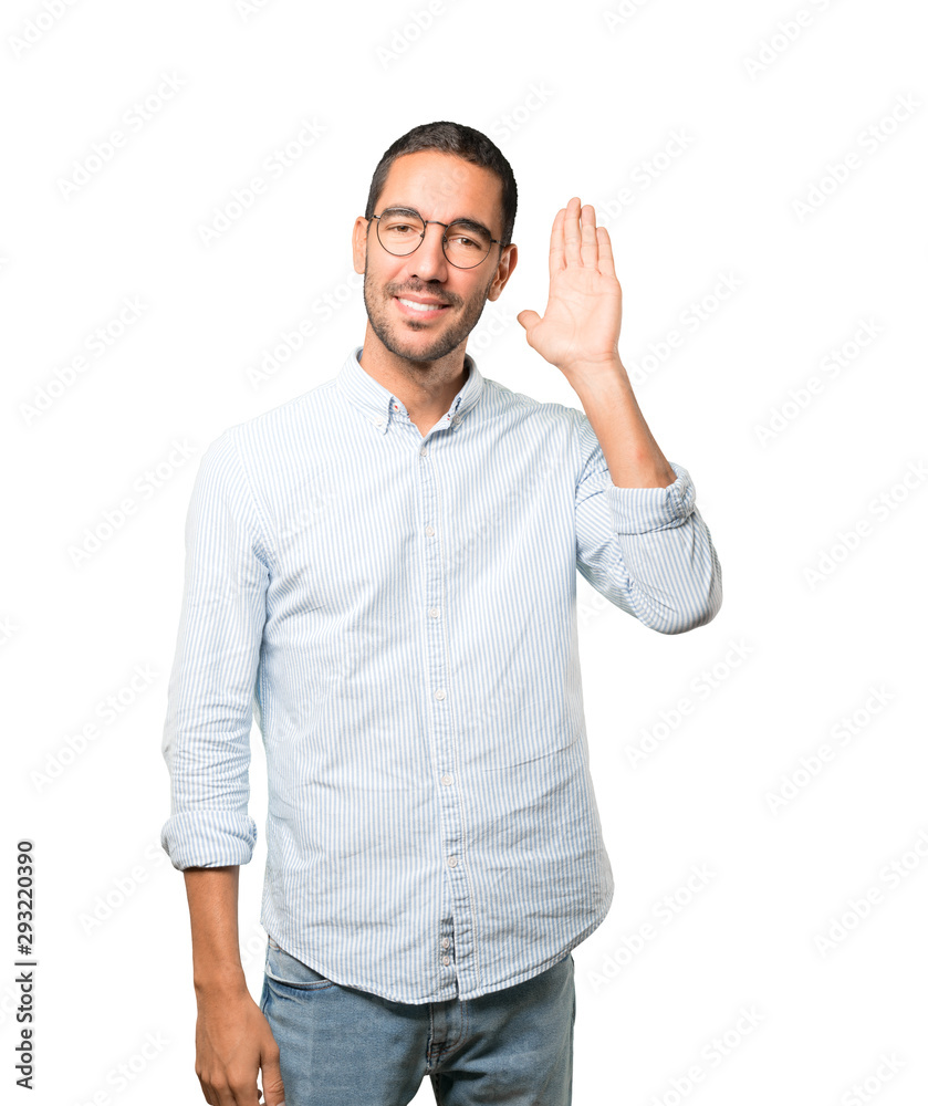 Happy young man smiling and making a gesture of trying to hear something Happy young man smiling and making a gesture of trying to hear something