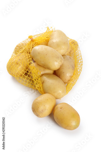 raw potatos in yellow string bag. Isolated on white background