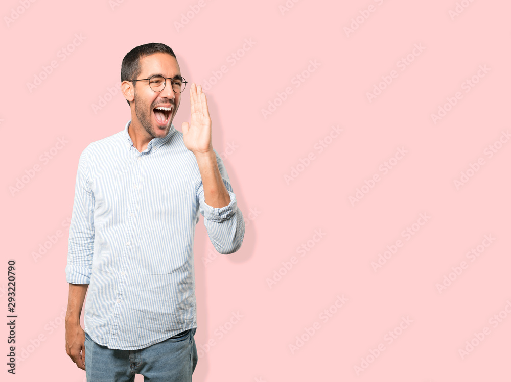 Happy young man trying to say something strongly Happy young man trying to say something strongly