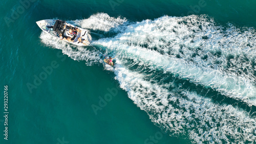 Aerial photo of woman practising waterski in Mediterranean bay with emerald sea at sunset photo
