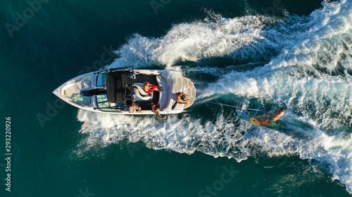 Obraz na płótnie Aerial photo of woman practising waterski in Mediterranean bay with emerald sea at sunset w salonie