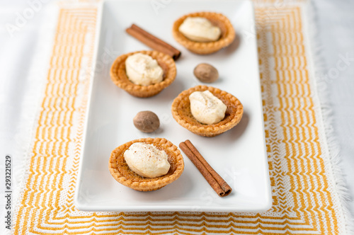 Mini butter tart with cream. Mini sugar pies (or butter tarts) with a crisp pastry crust, a sweet filling and pumpkin spice whipped cream on top. A tasty dessert for fall holidays like halloween!