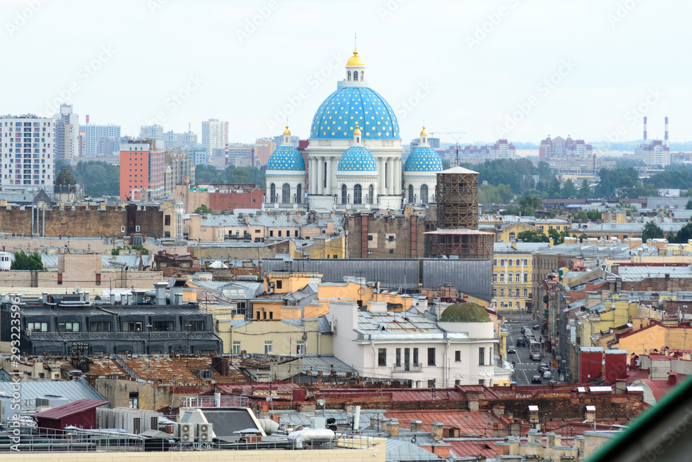 Fototapeta premium Cityscape view of the city of Saint Petersburg, Russia. in the midst of many roofs emerge the colorful blue domes of the famous Trinity Cathedral