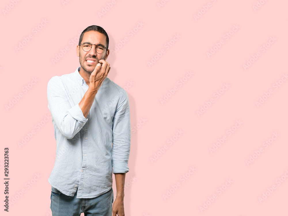 Concerned young man making a scratching gesture Concerned young man making a scratching gesture