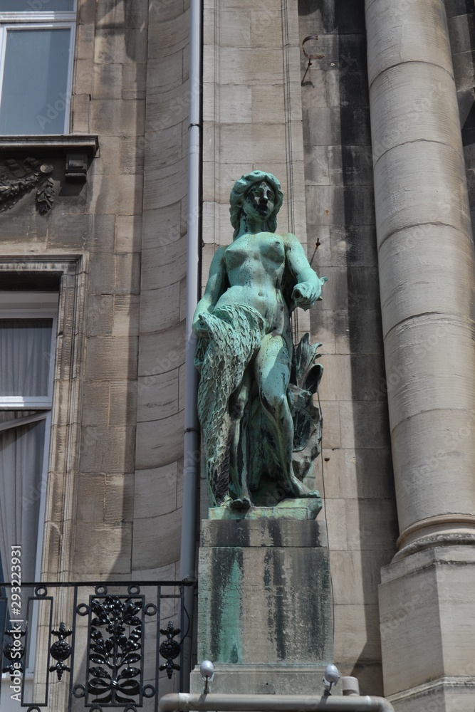 Graceful statue at the exterior of an old building, in Anvers, Belgium