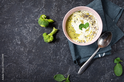 Broccoli cream soup and ingredients on black stone table