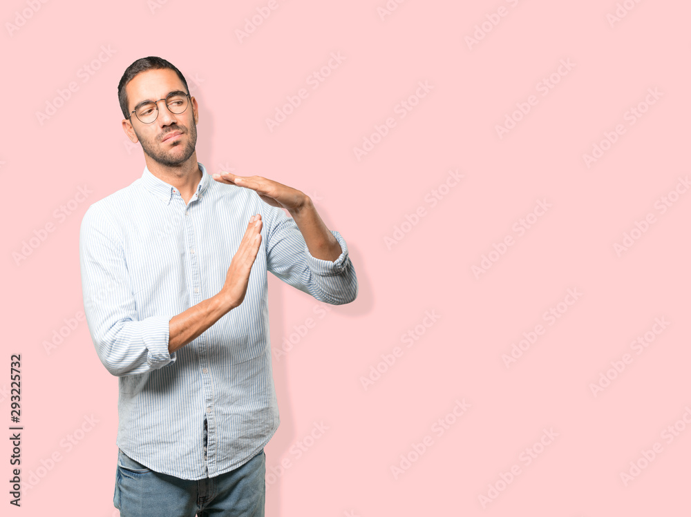Stressed young man making a time out gesture with his hands Stressed young man making a time out gesture with his hands