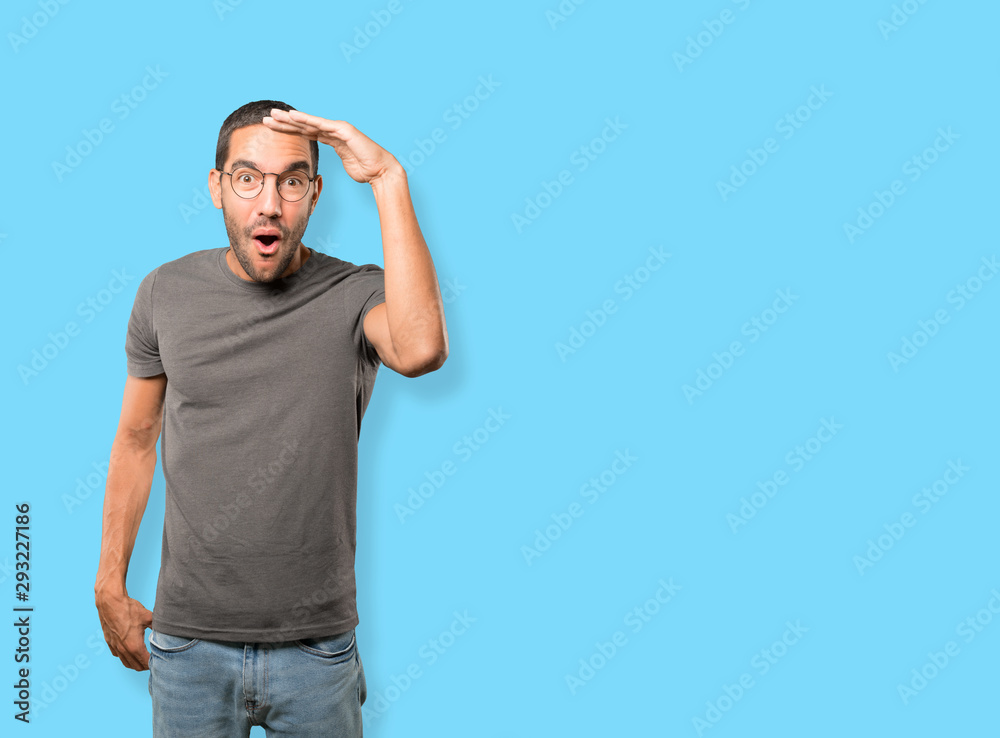 Fototapeta premium Astonished young man with a gesture of looking away