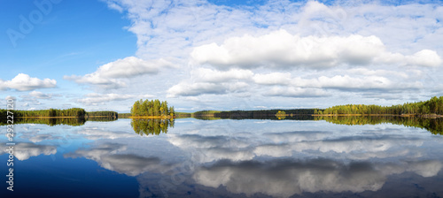 Fototapeta Naklejka Na Ścianę i Meble -   Landscape with the island on the lake and blue sky. Forest and beautiful blue sky with white clouds and reflection on the lake water.