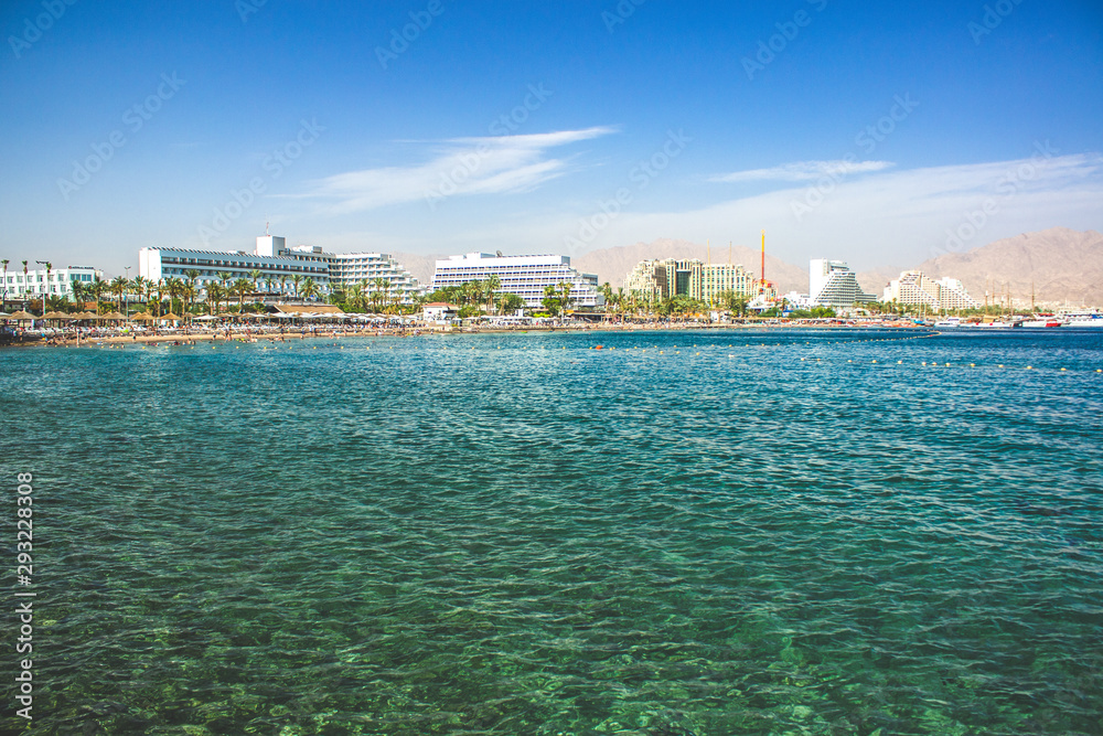 Red sea Israeli summer vacation destination Eilat south city urban view hotel waterfront background and Gulf of Aqaba water foreground 