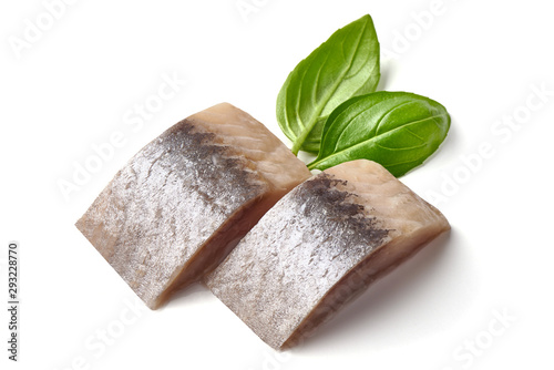 Salted marinated Atlantic herring with fresh green basil, isolated on white background