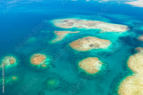 Coral reefs and lagoons, top view. Atolls and turquoise sea water. Sea surface.