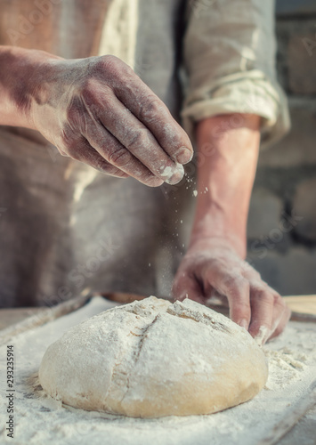 The Baker's hands under dough for wheat bread