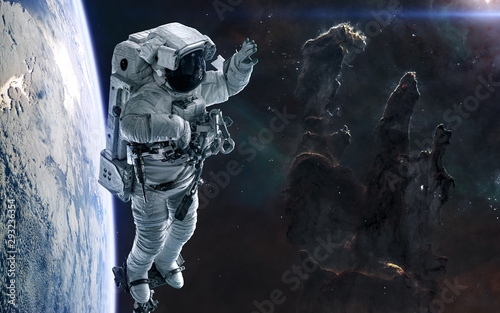 Pillars of Creation, astronaut, planet in deep space. Science fiction. Elements of this image furnished by NASA