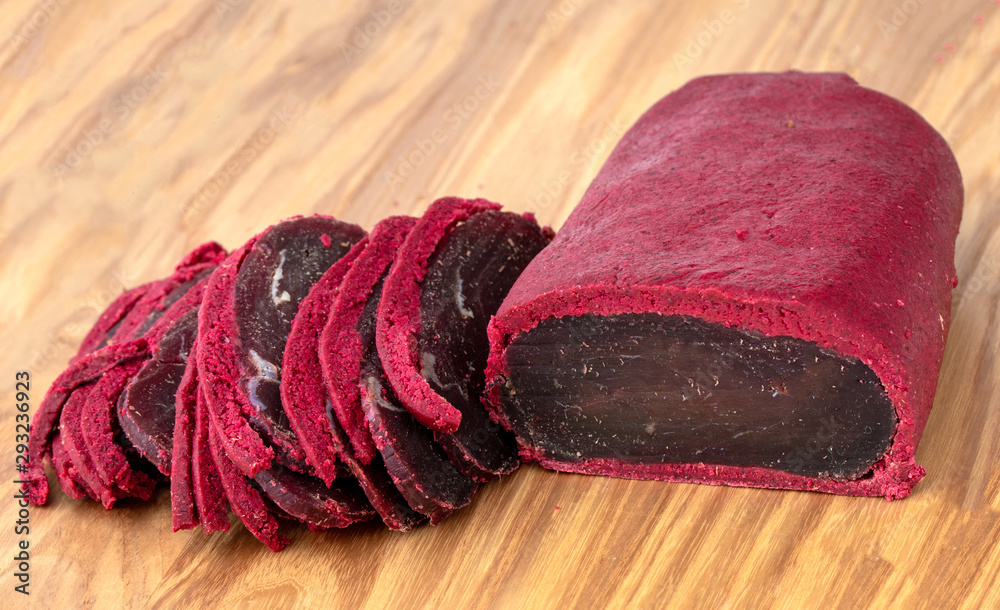 Fototapeta premium Cured meat on a wooden board. Close-up of basturma sliced into pieces.