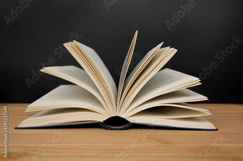 open paper book with open pages, reading concept, on a wooden table, horizontal, closeup, copy space