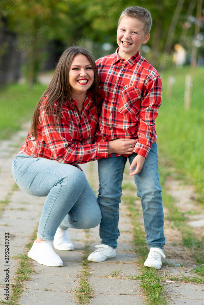 Fototapeta premium Mom and son are smiling happily on a walk in the park.