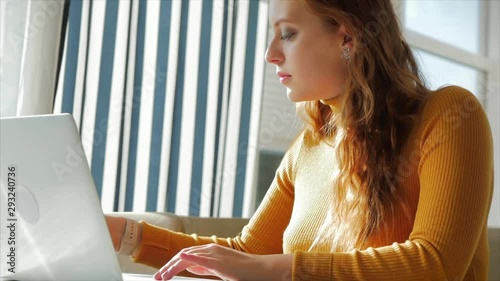 Beautiful Sunny Day Young Woman Drinks Morning Coffee in a Cafe, Making Online a Purchase Easy Payment on the Internet Using a Mobile Phone or Laptop. photo