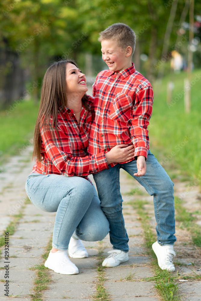 Fototapeta premium Mom and son are smiling happily on a walk in the park.