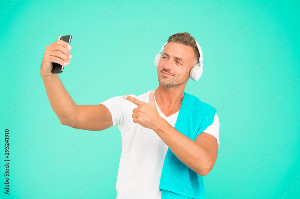 Hand selfie. Handsome man point finger at selfie camera in smartphone. Happy sportsman smiling take selfie with mobile phone. Enjoying selfie session after training Hand selfie. Handsome man point finger at selfie camera in smartphone. Happy sportsman smiling take selfie with mobile phone. Enjoying selfie session after training