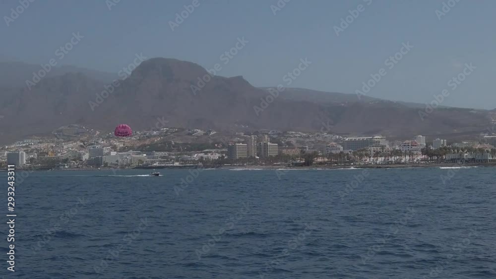ocean coast with hotel buildings and motor boat with parasail shot sailboat, Tenerife ocean coast with hotel buildings and motor boat with parasail shot sailboat, Tenerife