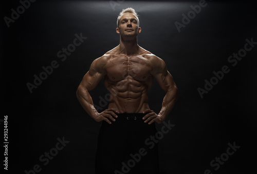 Fitness model man posing in studio