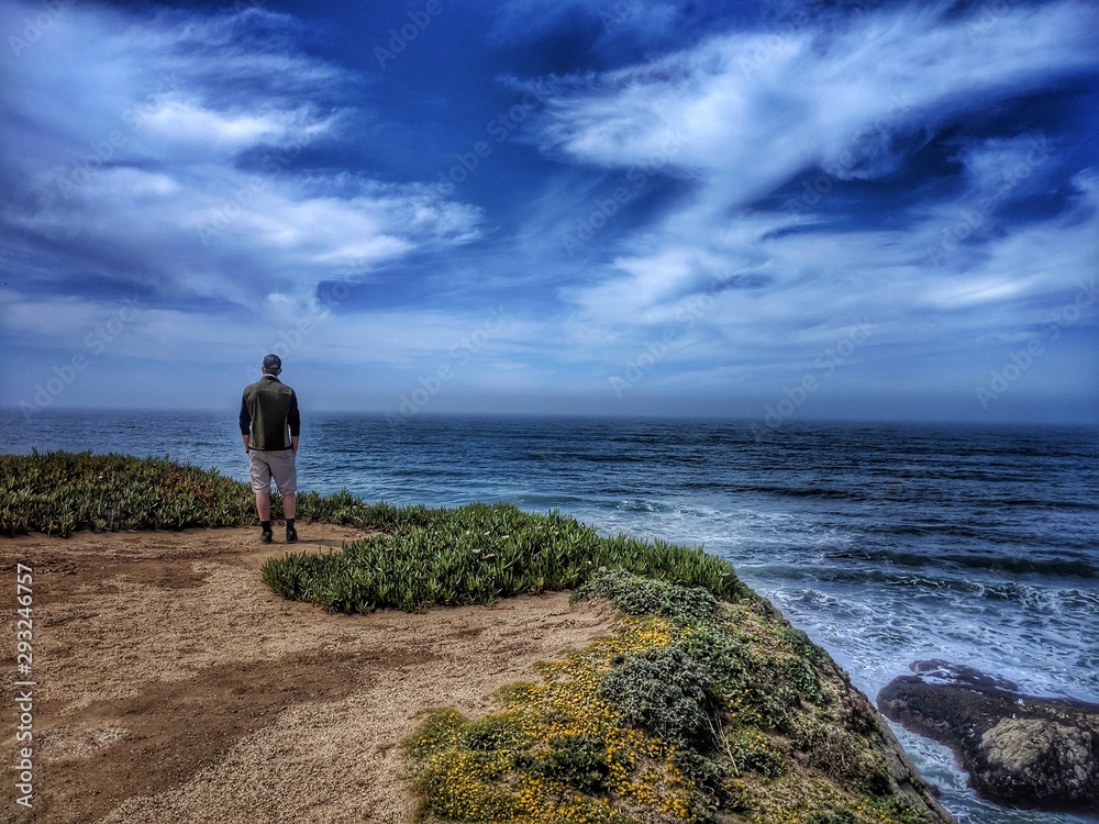Man gazing at ocean from Cliff's edge