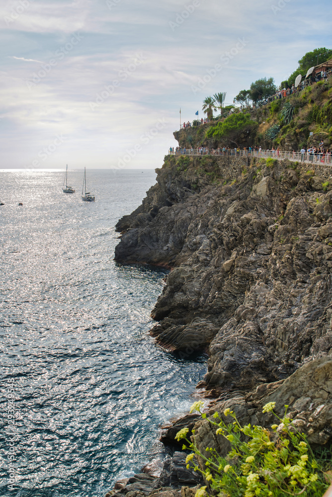 The rocky coast of the Ligurian Sea, yachts on the water, tourists on the Love Trail, Cinque Terre, Italy