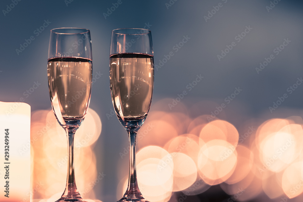 Pair of champaign glasses against beautiful city light bokeh. - obrazy, fototapety, plakaty 