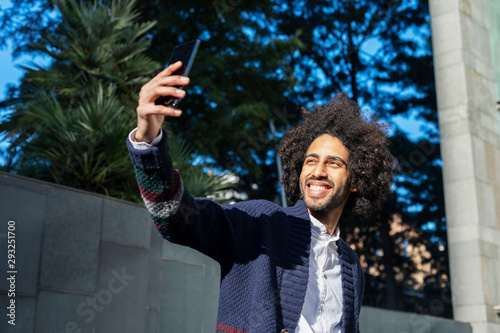 young afro american man smiling happy taking selfie self portrait picture with mobile phone