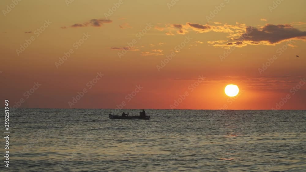 Fishermans boat on sea water during sunset time Fishermans boat on sea water during sunset time