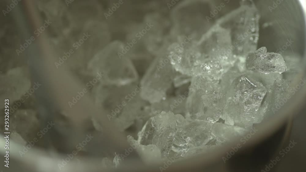 Close up of small metal spoon scooping crush ice of out an ice bucket. Close up of small metal spoon scooping crush ice of out an ice bucket.