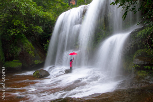 waterfall in forest with woman in background
