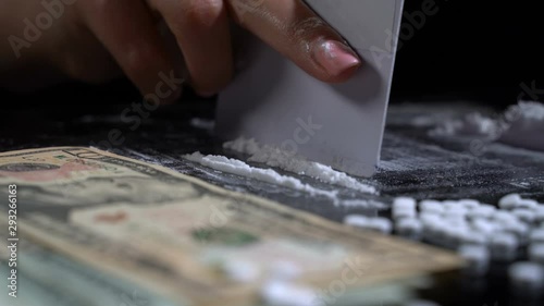 White cocaine powder on a table with dollar bills