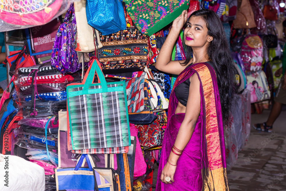 Beautiful Indian woman doing shopping in traditional sari for festival season and Diwali in local street market