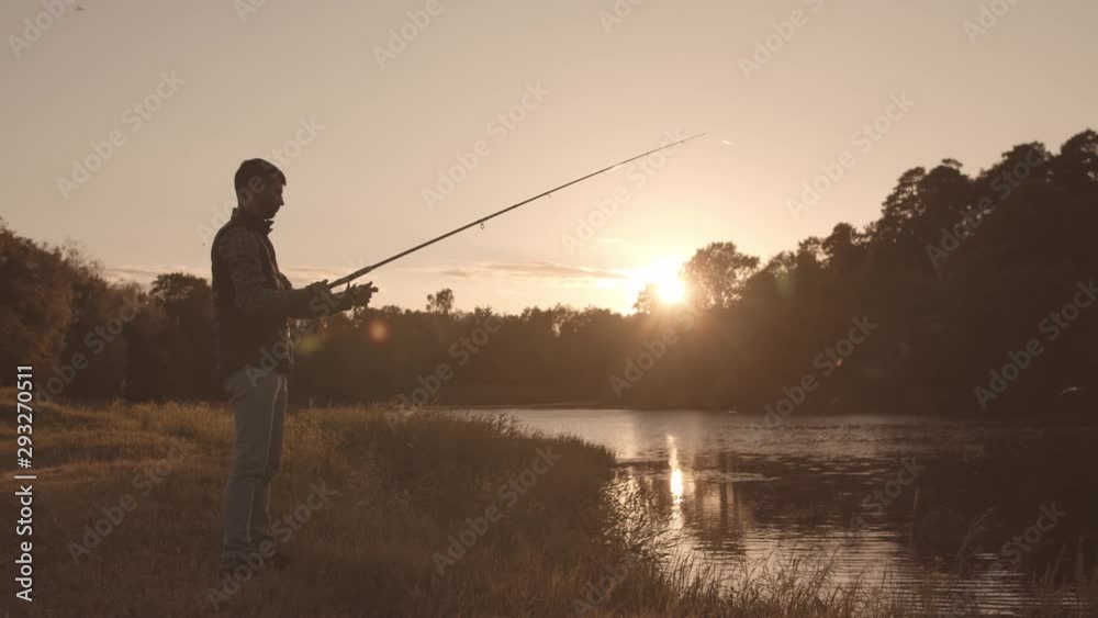 Fisherman with a spinning rod catching fish on a river. Fisher man on a weekend. Hobby, leisure and active summer and autumn concept. Fisherman with a spinning rod catching fish on a river. Fisher man on a weekend. Hobby, leisure and active summer and autumn concept.