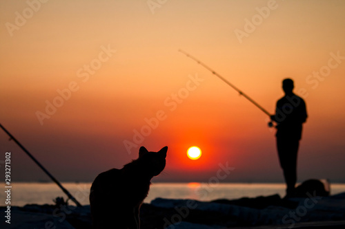A fisherman silhouette fishing at sunset. Freshwater fishing, catch of fish © stocktr