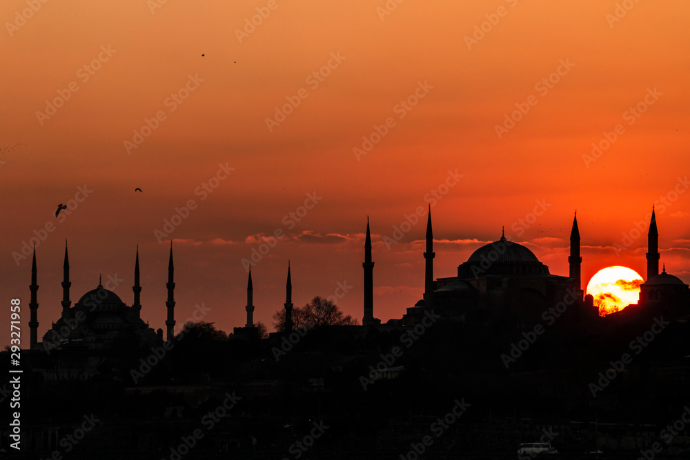 Cityscape of Istanbul with silhouettes of ancient mosques and minarets at sunset. Panoramic view, The Maiden's Tower, Galata Tower, Hagia Sophia, The Blue Mosque and Topkapı Palace in Istanbul.