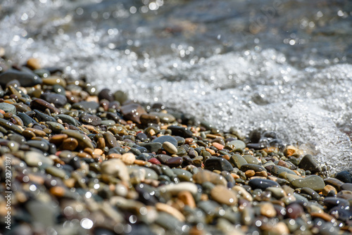 Wet pebbles and sea waves-the texture of the sea coast.