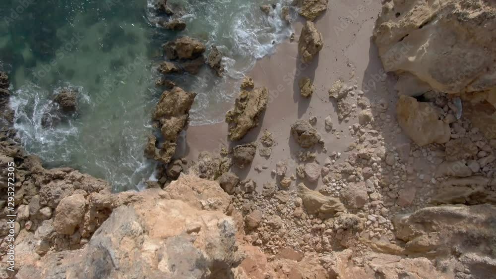 Top Down View Reveal of Private Rocky Beach into Ocean. Dolly from Vantage point Into Beach Top Down View Reveal of Private Rocky Beach into Ocean. Dolly from Vantage point Into Beach