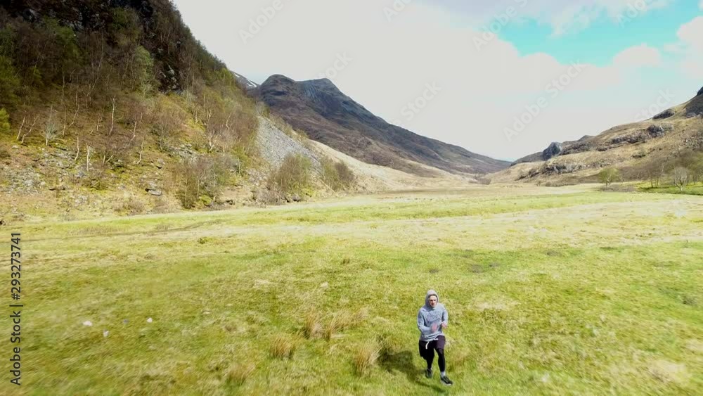 4K Man running through the Scottish Highlands. A runner in a summer mountain tourist landscape with a blue sky and clouds over a rural Scotland countryside landscape 4K Man running through the Scottish Highlands. A runner in a summer mountain tourist landscape with a blue sky and clouds over a rural Scotland countryside landscape